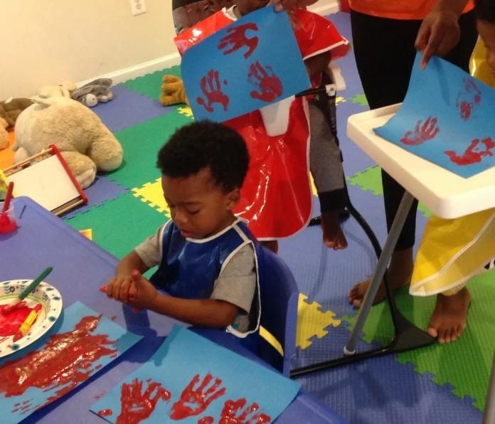Caring preschool teacher reading with children