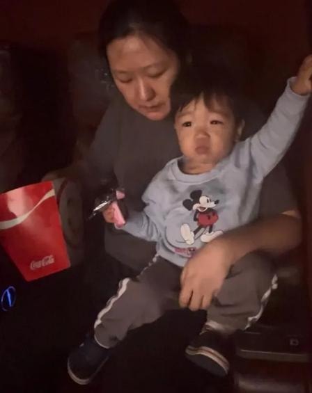 Caregiver holding a child during a family movie outing