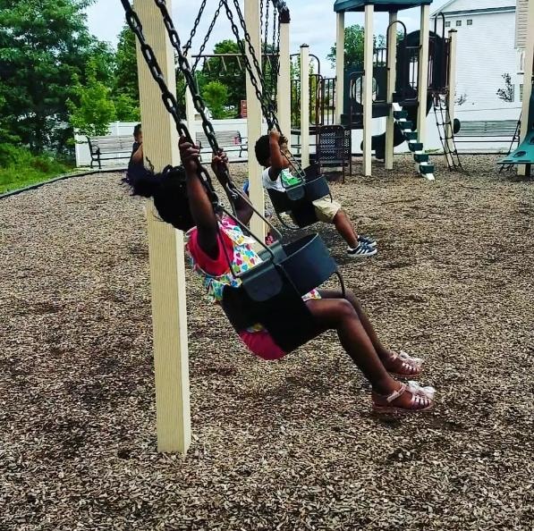 Children enjoying swings on the playground